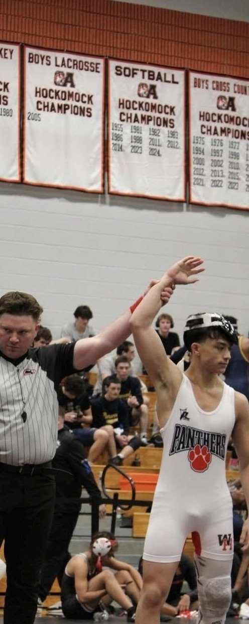 A Prime Athletics competition wrestling uniform worn in a match as the referee raises the winner's hand